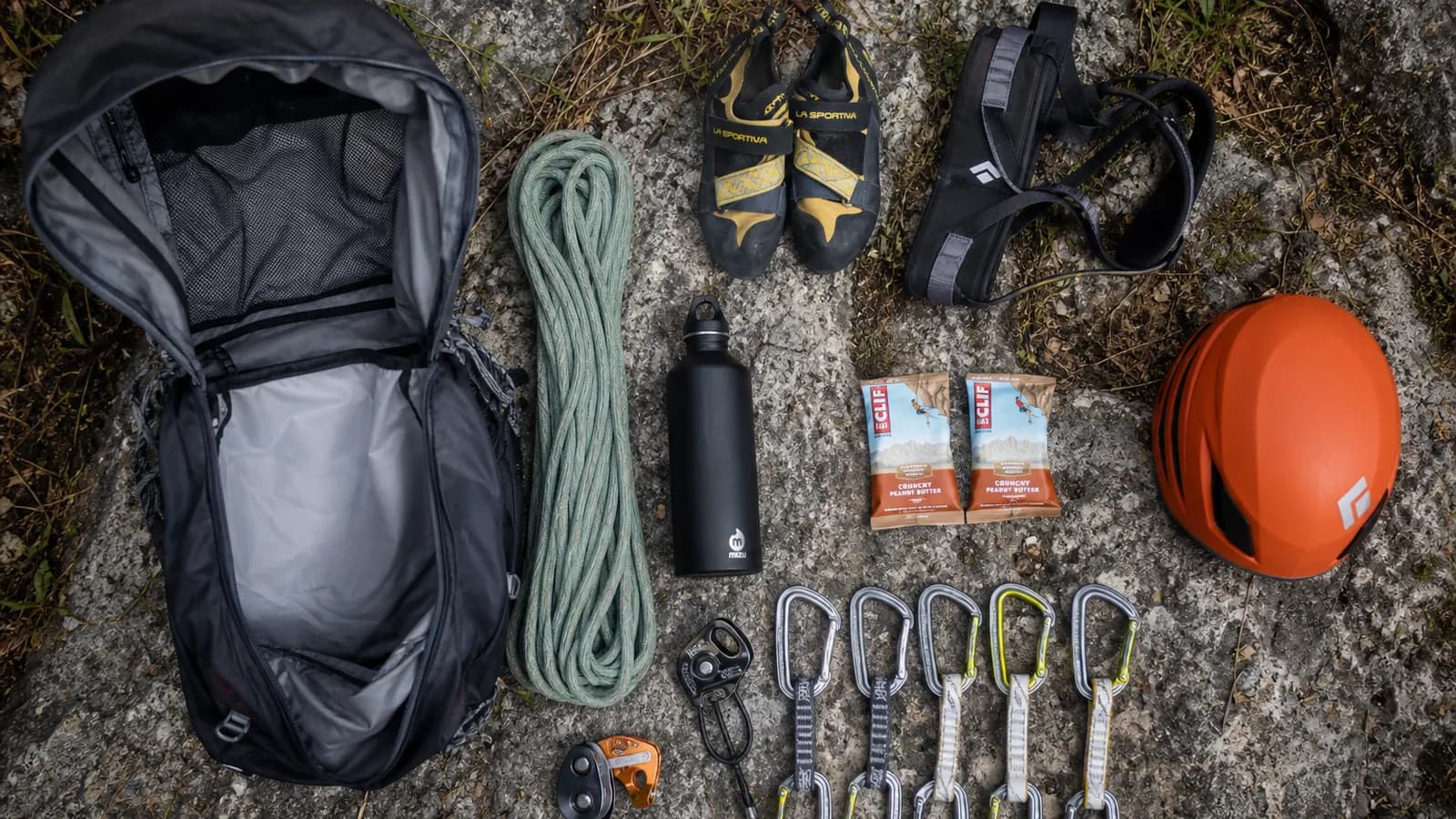 Sac à corde Petzl Kab ouvert avec corde lovée bâche dépliée et matériel d'escalade organisé